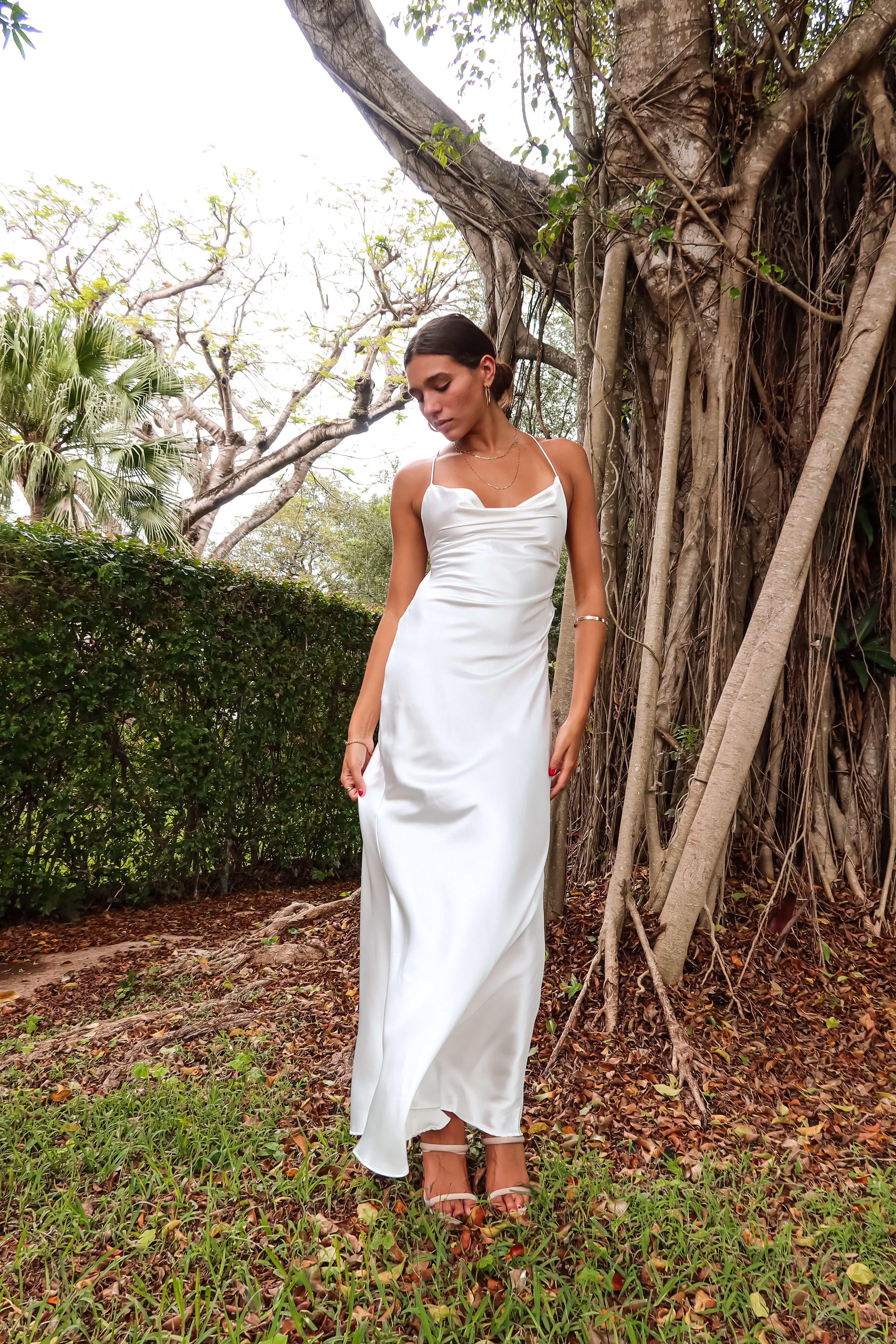 Get ready to party in our white satin maxi dress! Luxurious and thick satin fabric provides ultimate comfort and style. Adjustable string tie with gold chain detail adds a touch of glamour. Cowl neck bust and low back create a stunning silhouette. Let's get this party started!