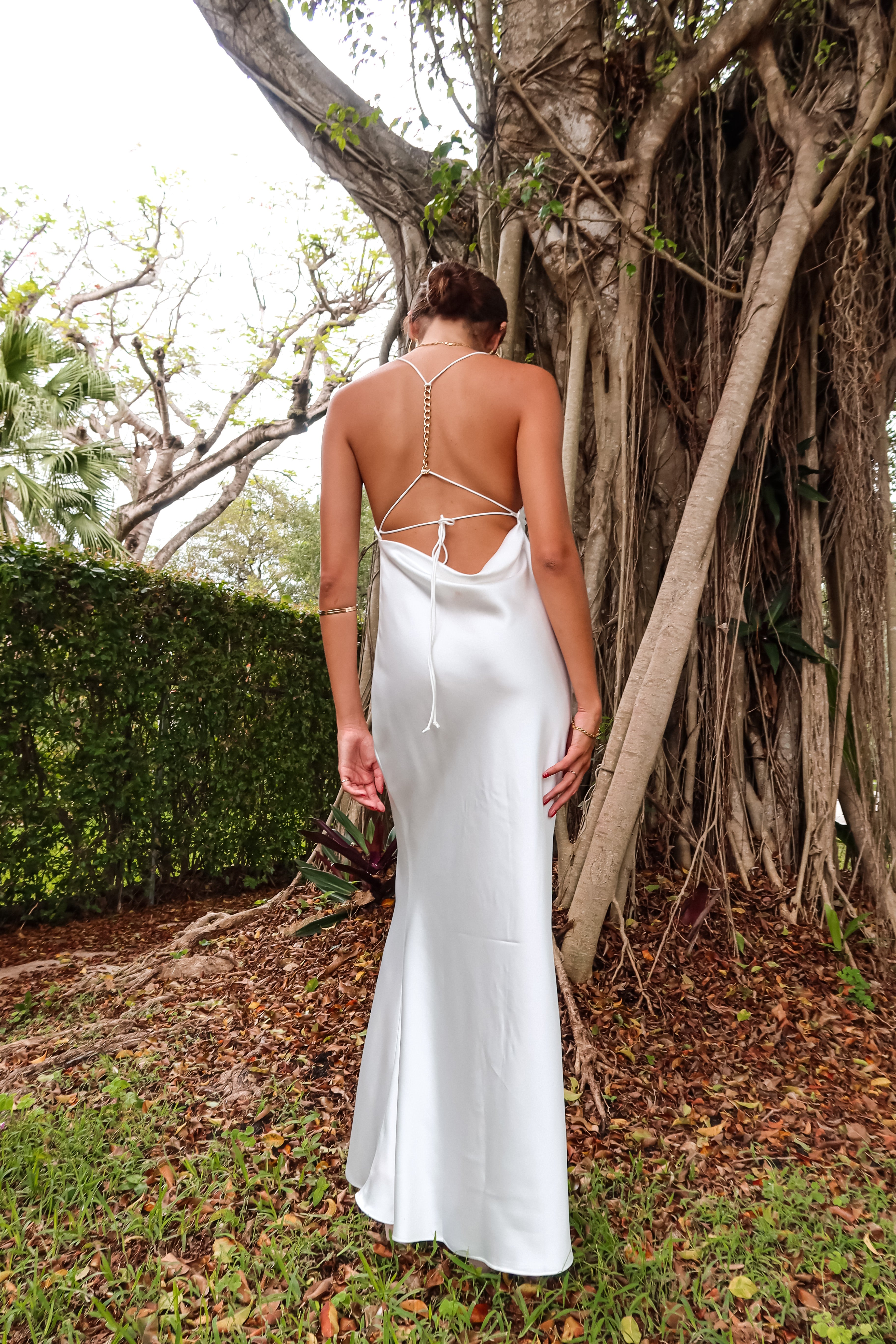 Get ready to party in our white satin maxi dress! Luxurious and thick satin fabric provides ultimate comfort and style. Adjustable string tie with gold chain detail adds a touch of glamour. Cowl neck bust and low back create a stunning silhouette. Let's get this party started!