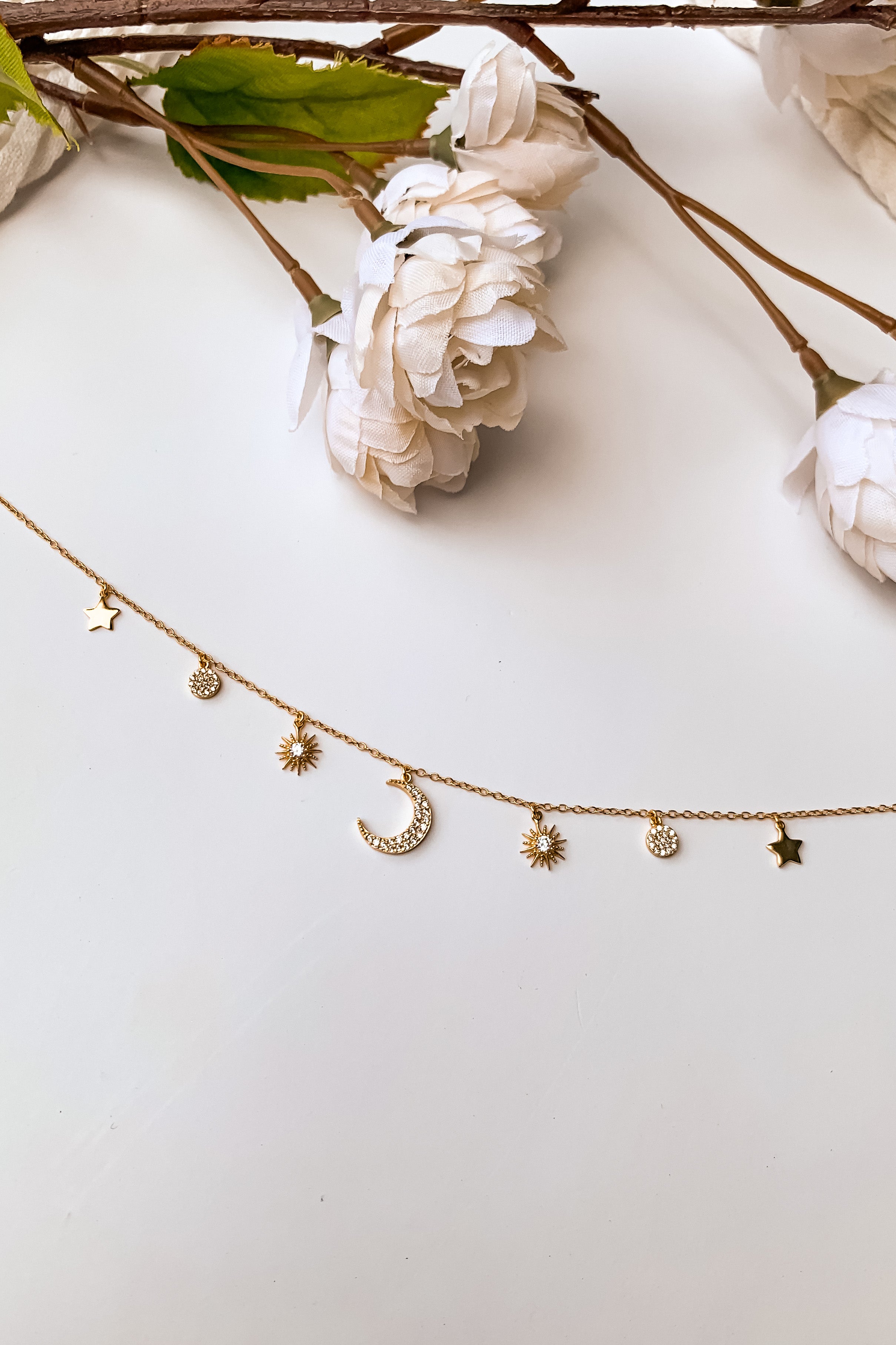 best selling Moon + Stars Necklace. This gold plated choker features a delicate moon and star charm and a secure spring ring clasp closure. With an adjustable 13 inch chain and 2 inch extender, it's crafted with high quality 925 sterling silver