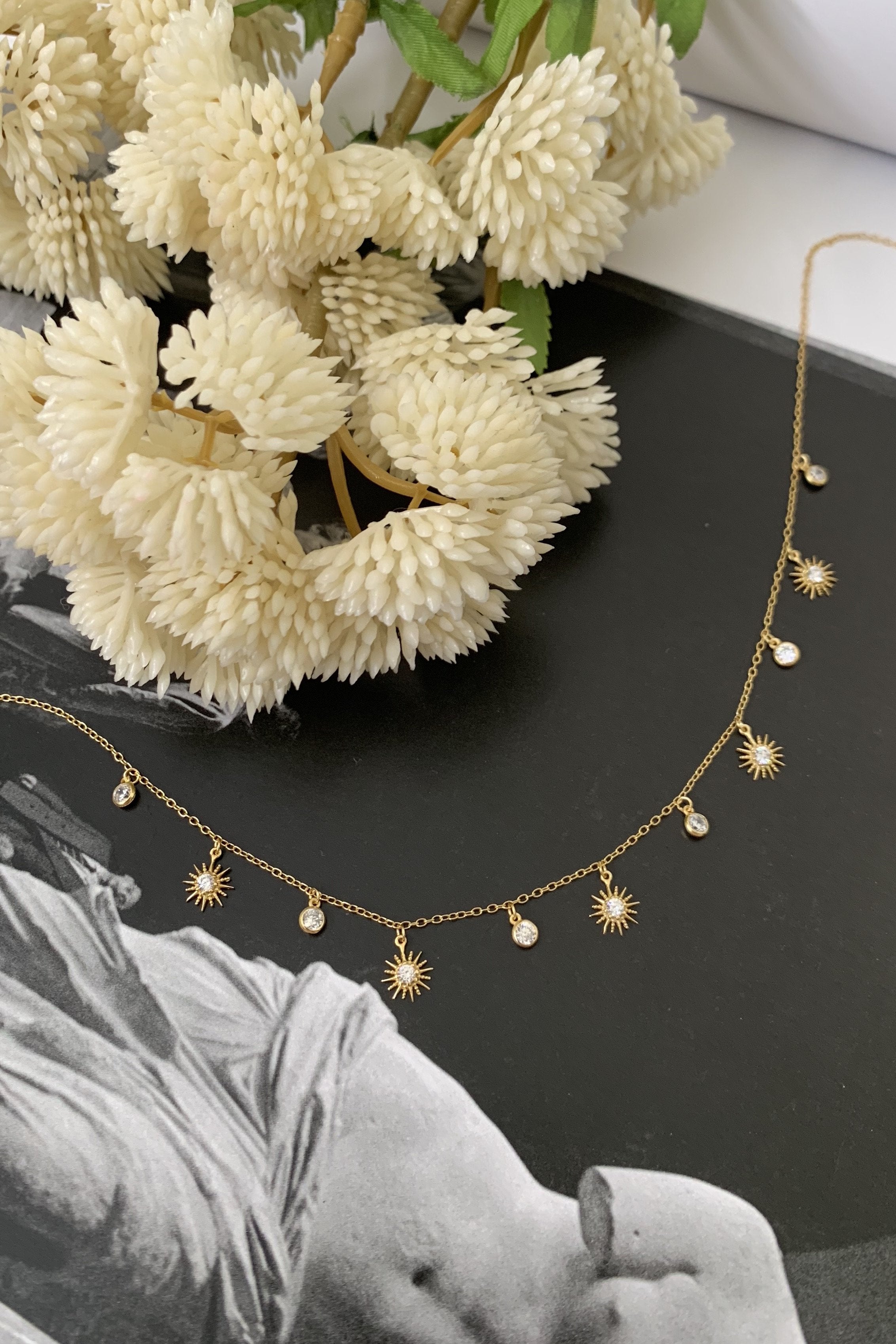 Let your style reach new heights with our OH MY STARS CHOKER! This gold plated choker features a star and moon charm, adding a touch of whimsy to any outfit. The 13 inch chain includes a 2 inch extender for a comfortable fit, and the spring ring closure ensures it stays securely in place. Gold plated over sterling silver for a luxe look.