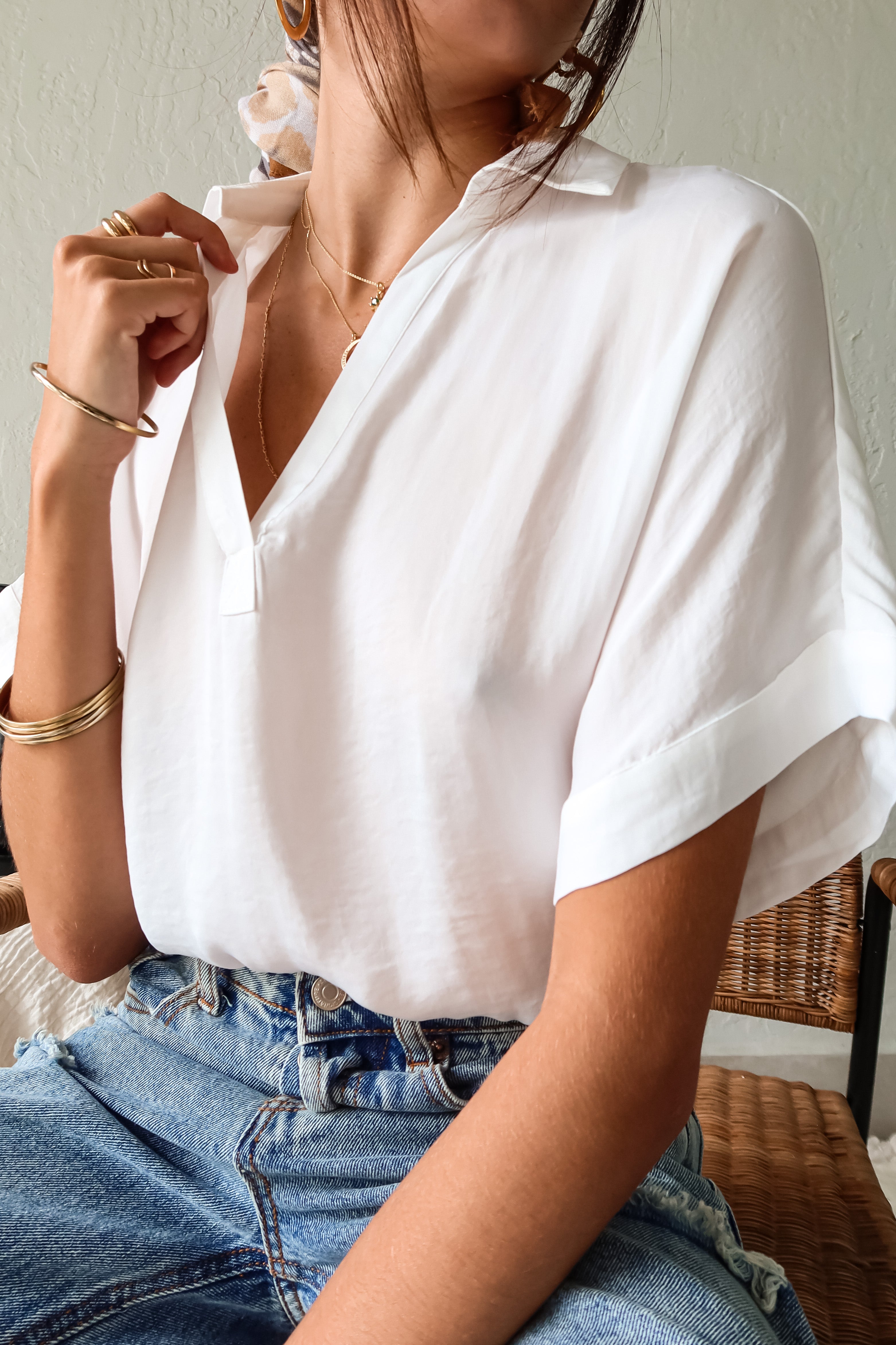  DOWNTOWN BLOUSE in classic white is a best seller for a reason. With a v-neck collared design and lightweight satin feel, this top is effortlessly chic. The cuffed sleeve adds a touch of sophistication. 